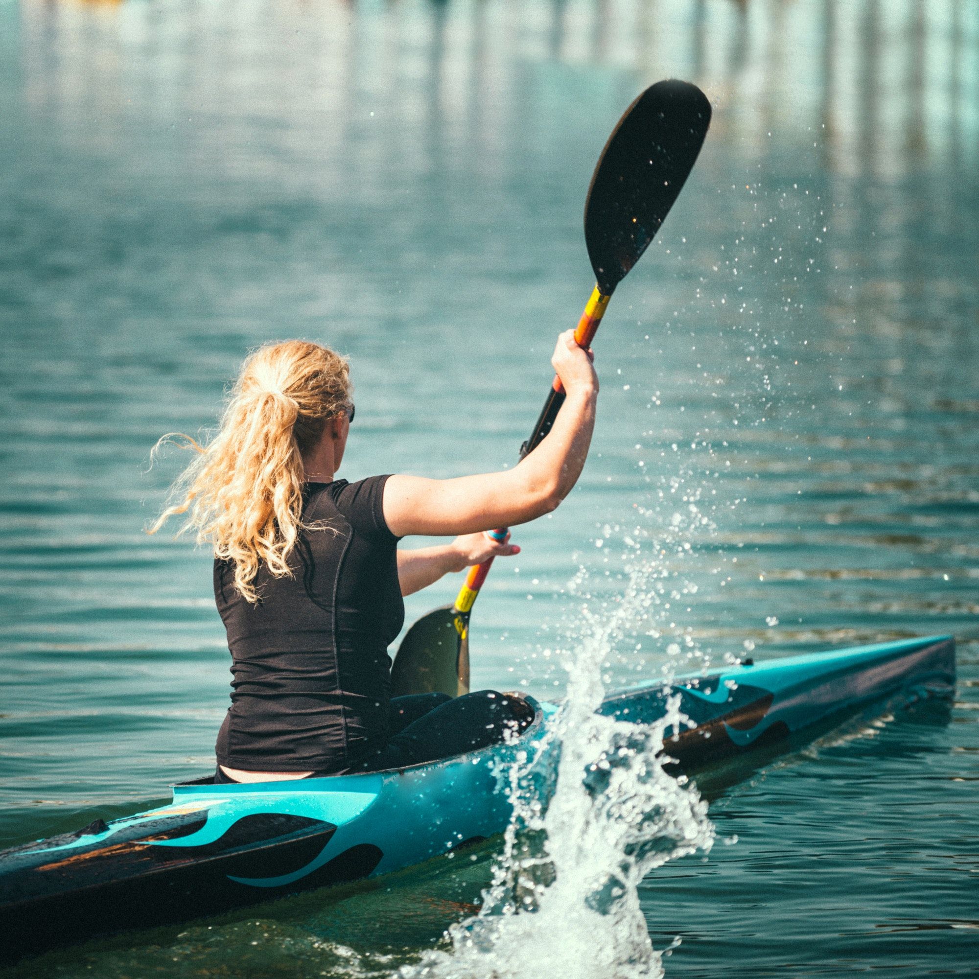 Female kayaker training on lake